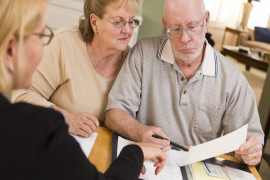 Senior Adult Couple Going Over Papers in Home with Agent